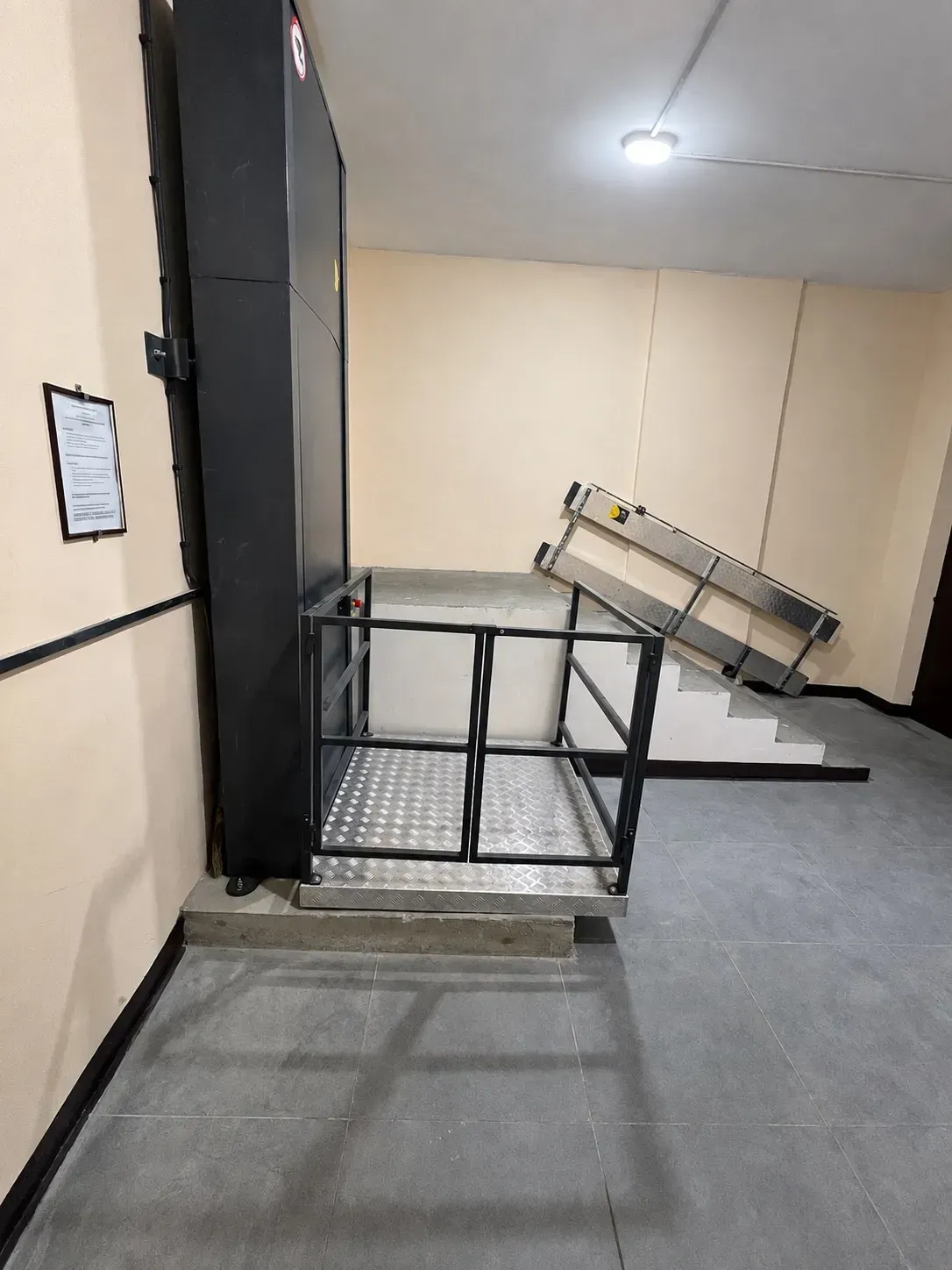 Платформа гідравлічного підйомника та складений пандус біля сходів у Києві