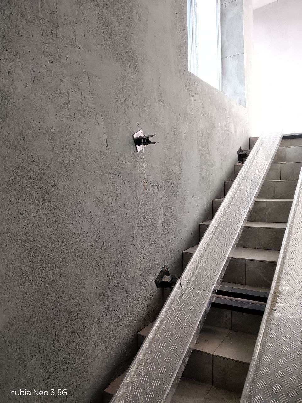 Wall mounts and rails of a long fold-down stair ramp